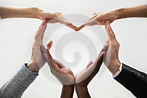 Concept of diverse business people join hands forming heart.