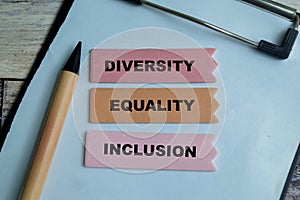 Concept of Diversity, Equality, Inclusion write on sticky notes isolated on Wooden Table