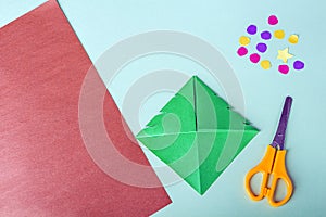 Concept of DIY and kid`s creativity, origami. Step by step instruction: how to make bookmark as christmas tree. Step 7 make cuts