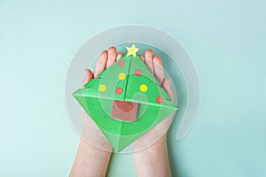Concept of DIY and kid`s creativity, origami. Step by step instruction: how to make bookmark as christmas tree. Step 9 Child`s