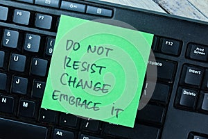 Concept of Do Not Resist Change Embrace it write on sticky notes isolated on Wooden Table