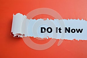 Concept of Do It Now Text written in torn paper