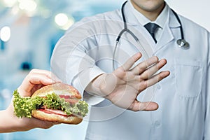 Concept of a doctor prohibiting eating fast food photo