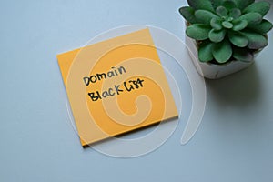 Concept of Domain Blacklist write on sticky notes isolated on Wooden Table