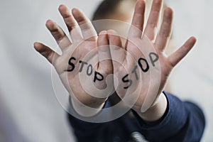 Concept of domestic violence and child abusement. A little girl shows her hand with the word STOP written on it. Children violence