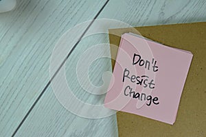 Concept of Don`t Resist Change write on sticky notes isolated on Wooden Table