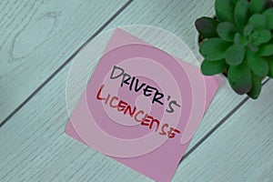 Concept of Driver`s License write on sticky notes isolated on Wooden Table