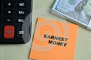 Concept of Earnest Money write on sticky notes isolated on Wooden Table photo