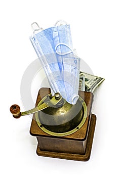 the concept of earning money on a pandemic in a manual coffee grinder medical masks are ground and the output is cash