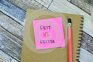 Concept of Ebit vs Ebitda write on sticky notes isolated on Wooden Table