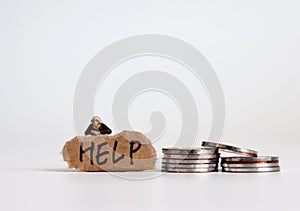 A letter of HELP on a torn piece of paper with a miniature woman. Miniature people and coins.