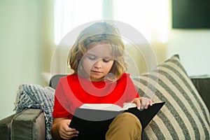 Concept of education, childhood, book reading, , artwork, inspiration. Child reading book at home. Little boy sitting on