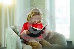 Concept of education, childhood, book reading, artwork, inspiration. Young teenager boy alone at home red book