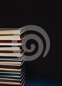 Concept Of Education And Knowledge. Tower Of Old Multicolored Books On A Black Background