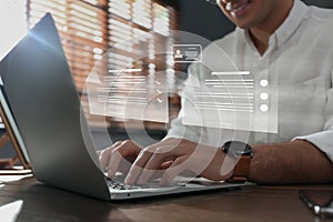 Concept of electronic signature. Man working on laptop at wooden table indoors, closeup