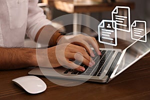 Concept of electronic signature. Man working on laptop at wooden table indoors, closeup