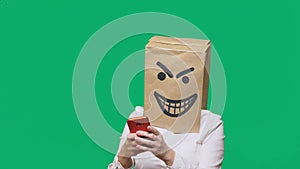 Concept of emotion, gestures. a man with a package on his head, with a painted smiley angry, sly, gloating