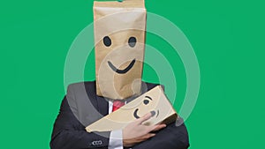 Concept of emotions, gestures. man with a package on his head, with a painted emoticon, smile, joy, laughter. plays with