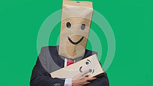 Concept of emotions, gestures. man with a package on his head, with a painted emoticon, smile, joy, laughter. plays with