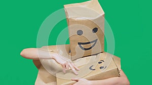 Concept of emotions, gestures. man with a package on his head, with a painted emoticon, smile, joy, laughter. plays with