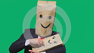 Concept of emotions, gestures. man with a package on his head, with a painted emoticon, smile, joy, laughter. plays with