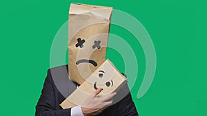 Concept of emotions, gestures. man with a package on his head, with a painted emoticon, smile, joy, laughter. plays with