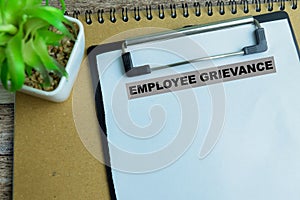 Concept of Employee Grievance write on paperwork isolated on wooden background