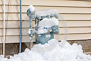 Natural gas meter covered in snow during winter photo