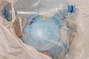 The concept of environmental pollution by plastic waste. Globe is in a bag with plastic trash. A model of the planet Earth was thr