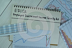 Concept of ERISA - Employee Retirement Income Security Act write on a book isolated on Wooden Table