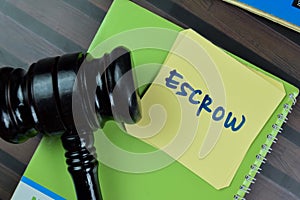 Concept of Escrow write on sticky notes with gavel isolated on Wooden Table