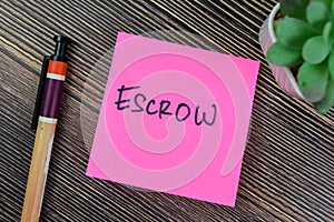 Concept of Escrow write on sticky notes isolated on Wooden Table