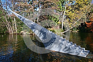 Concept of eternity and infinity. Stairs sculpture with sharp point entitled Diminish and Ascend rising from water to air