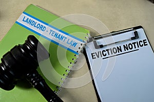 Concept of Eviction Notice on document form and book landlord-Tenant law isolated on Wooden Table