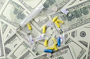 Concept of expensive health care.Pills and syringe on the banknote background