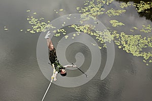 Concept of Extreme Sports and Fun. One  man is a  thrill-seeker and a  rope jumper from the bridge. He is very happy to make a