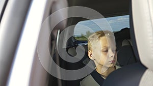 The concept of a family holiday. A school child sits in the back seat of a car and looks out the window enjoying the