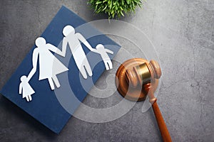 The concept of family law. Family with children cutout and gavel on table.