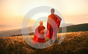 Concept of father`s day. dad and child daughter in hero superhero costume at sunset photo