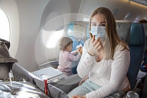 Concept fear of travel because of coronavirus covid-19..a young mother is sitting in an airplane chair in a medical