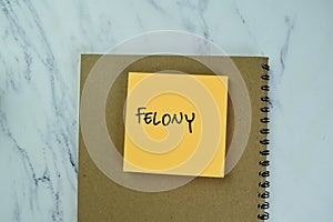 Concept of Felony write on sticky notes isolated on Wooden Table