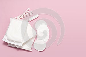 The concept of feminine hygiene, tampons, pads on a pink background