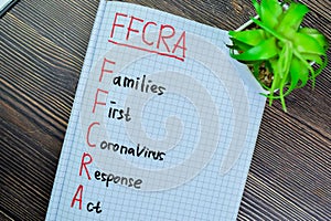Concept of FFCRA - Families First Coronavirus Response Act write on book isolated on Wooden Table photo