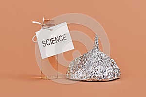 Concept for fighting conspiracy theories with science with tinfoil hat and cure bottle