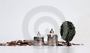 Concept about finance with miniature people and coins.