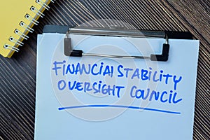 Concept of Financial Stability Oversight Council write on paperwork isolated on Wooden Table photo