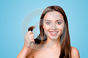 Concept of finding a good solution in treating damaged hair ends. Pretty cute smiling woman is showing her healthy hair