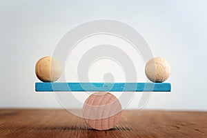 Concept of finding the right balance. Wooden balls on seesaw