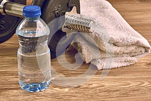 Concept fitness equipment with dumbbell, bottle of water and towel.