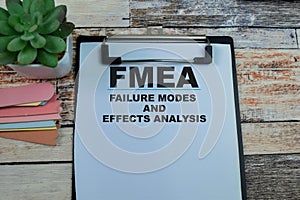 Concept of FMEA - Failure Modes and Effects Analysis write on paperwork isolated on wooden background photo